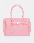 A baby pink jelly handbag with silver-tone hardware, featuring a front flap, top handles, and a hanging clochette, photographed against a light gray studio background.