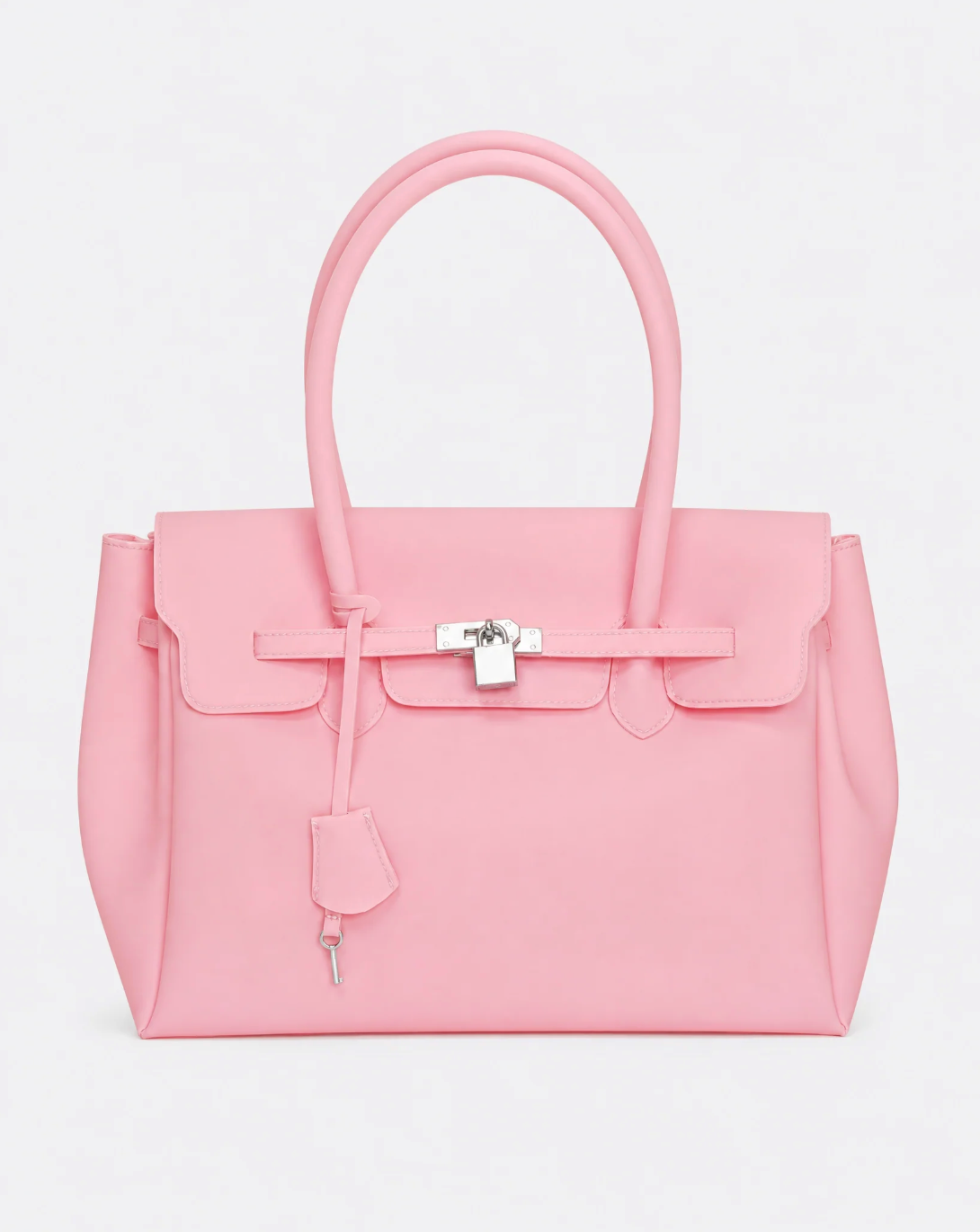 A baby pink jelly handbag with silver-tone hardware, featuring a front flap, top handles, and a hanging clochette, photographed against a light gray studio background.
