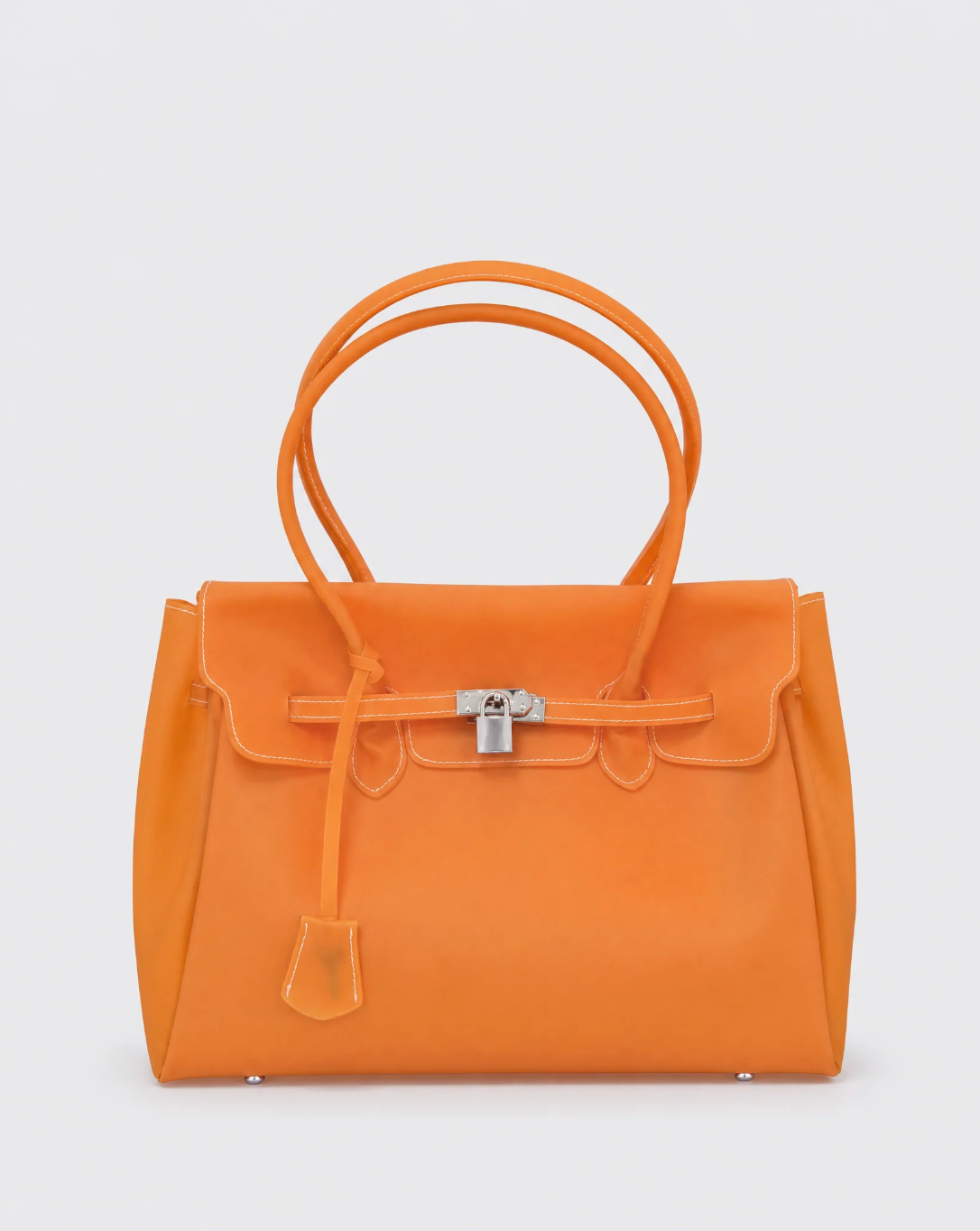 An orange jelly handbag with double top handles, a front flap, and a silver-toned turn-lock closure, photographed against a light gray background.