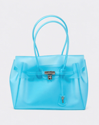 A translucent light blue jelly handbag with double top handles, a front strap closure, and a silver lock,