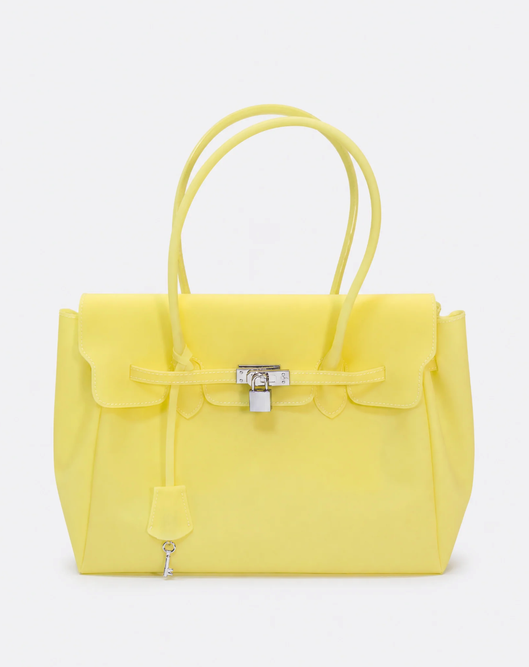 A bright yellow structured handbag with double top handles, a front flap, a drawstring detail, and a silver padlock closure, photographed against a clean white background.